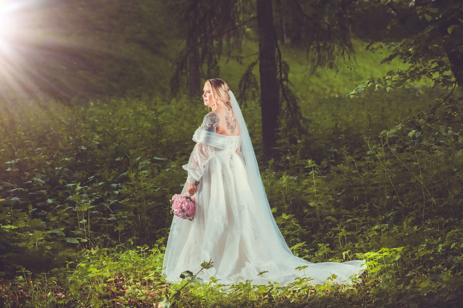 Bryllupsfotograf Oslo – brud med rosa blomster og slør i grønn og fredelig skog