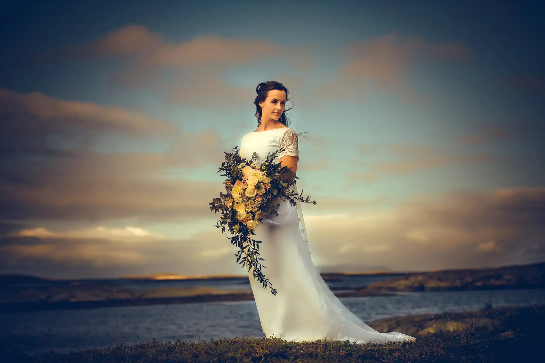 Bryllupsfotograf Oslo – brud med blomster ved vann i gyllent kveldslys