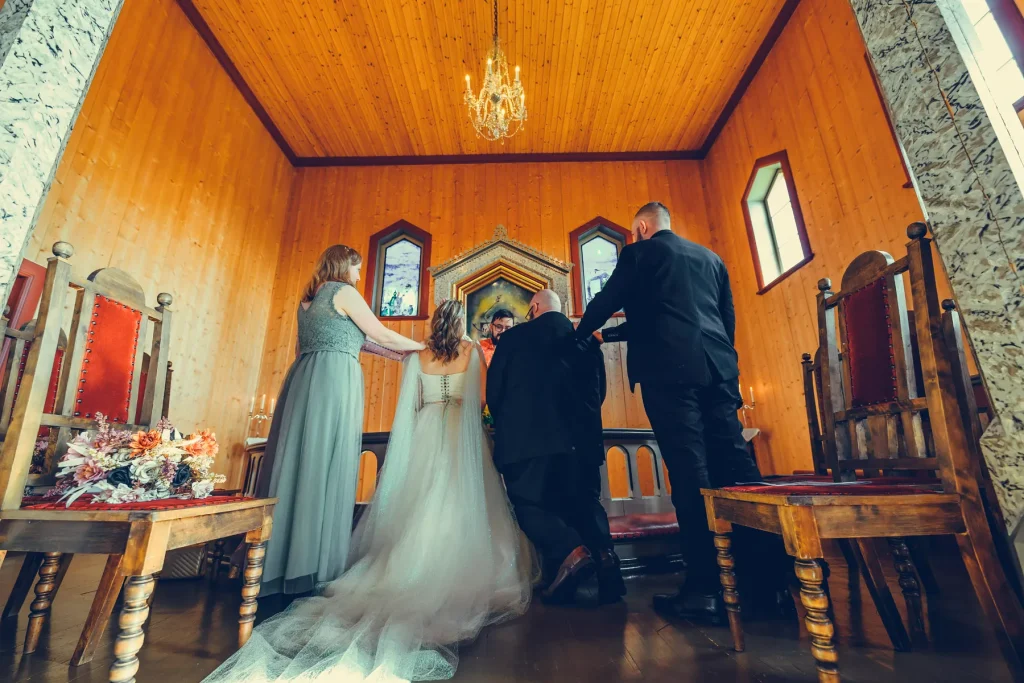 Brudeparet danser under lysekronen i Sørskogbygda Kirke omgitt av varme lys.
